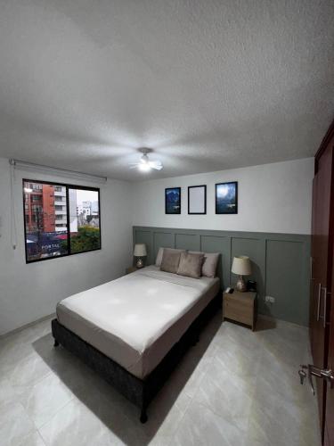 a bedroom with a large bed and two windows at Apartamento en Pereira - Pinares in Pereira