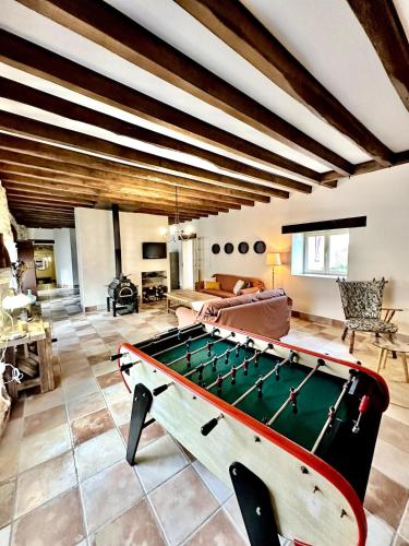 a living room with a pool table in the middle at Aux Détours de l'Étang La Bergerie et sa piscine privative in Château-Chervix