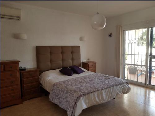 ein Schlafzimmer mit einem großen Bett mit lila Kissen in der Unterkunft Villa Acebo in Nerja