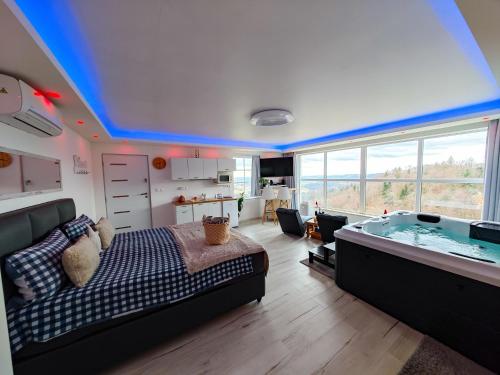 a bedroom with a bed and a tub in a room at Wellness pod zvezdami, Maribor - PRIVATE in Maribor