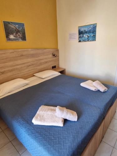 a bedroom with a blue bed with towels on it at Iskas apartments in Ialysos