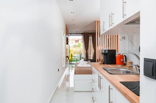 a kitchen with white cabinets and a sink at Studio D1 in Kallithea Halkidikis