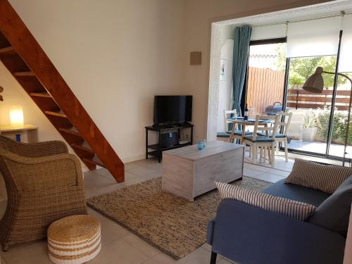 un salon avec un canapé et une télévision dans l'établissement Gruissan Ayguades maison de vacances L'Etang 4 personnes, à Gruissan