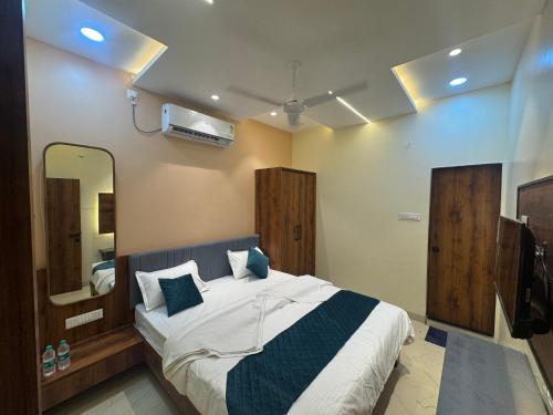 a bedroom with a large bed and a mirror at Hotel Tulsi inn in Ellora