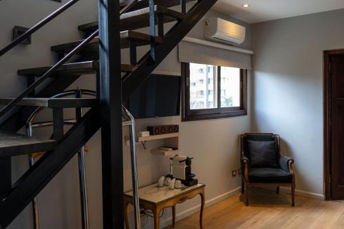 a room with a staircase and a chair at Miravida Soho Hotel & Wine Bar in Buenos Aires