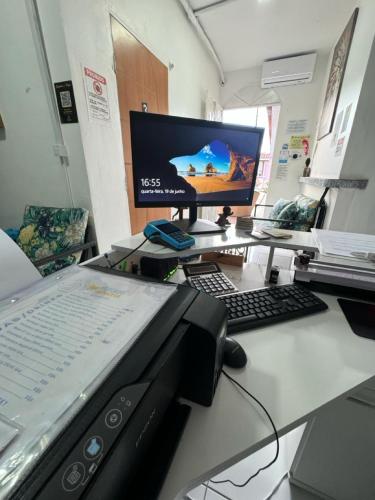 a desk with a computer and a monitor and keyboard at Residencial Napolitan in Manaus
