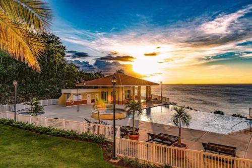 a house by the ocean with the sun setting at Brisas de Campo in Aguadilla