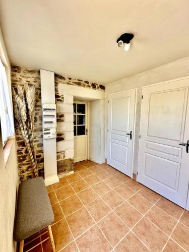 a hallway with a door and a chair in a room at Aux Détours de l'Étang La Bergerie et sa piscine privative in Château-Chervix