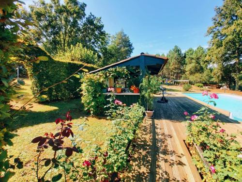 un jardin avec une piscine et un pavillon dans l'établissement Maison familiale de campagne, à Marsaneix