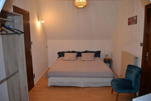 une chambre avec un lit et une chaise bleue dans l'établissement Maison familiale de campagne, à Marsaneix