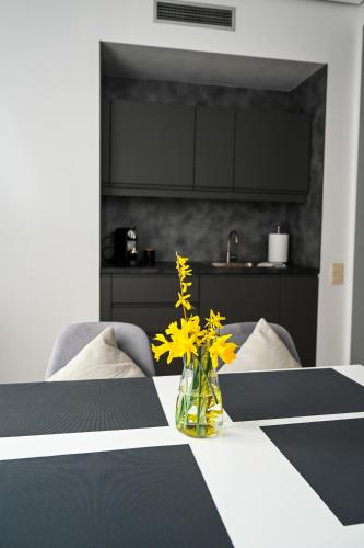 a vase with yellow flowers sitting on a table at Domus Revado in Birštonas