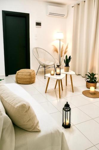 a bedroom with a bed and a chair and tables at Riviera in Agios Nikolaos