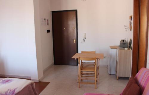 a room with a table and two chairs and a door at POESIS ROOM in Quartu SantʼElena