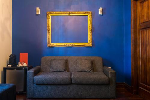 a blue living room with a couch and a mirror at Miravida Soho Hotel & Wine Bar in Buenos Aires