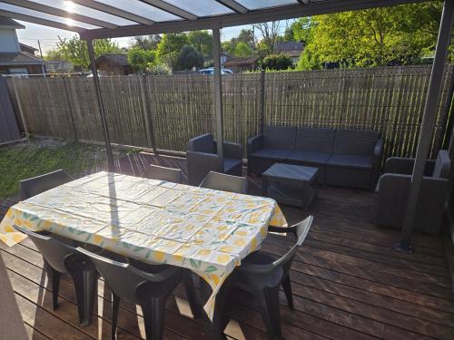 a table and chairs on a deck with a table and a couch at Cabane Miossaise in Mios