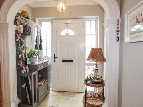 a hallway with a white door and a lamp at Donagh Cross Town House in Carndonagh