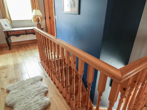 a wooden staircase with a rug on the floor at Donagh Cross Town House in Carndonagh