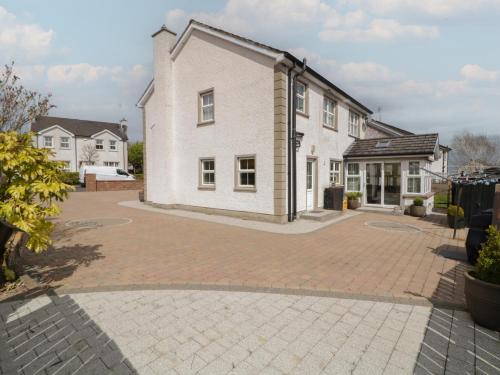 a large white house with a brick driveway at Donagh Cross Town House in Carndonagh