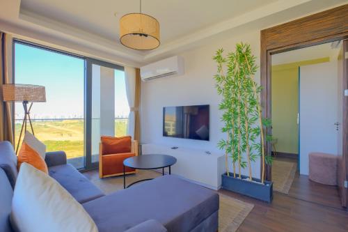a living room with a blue couch and a plant at Modern Furnished Apartments in Istanbul Basaksehir By Iradah Gayrimenkul in Basaksehir
