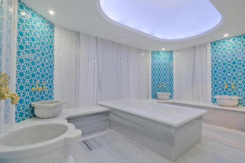 a bathroom with a tub and a toilet and a sink at Modern Furnished Apartments in Istanbul Basaksehir By Iradah Gayrimenkul in Basaksehir