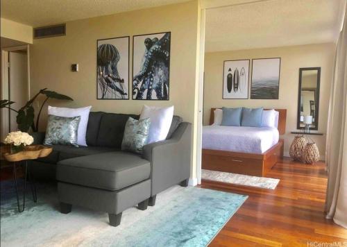 a living room with a couch and a bed at Makaha Valley Oasis 1-Bedroom apts in Waianae