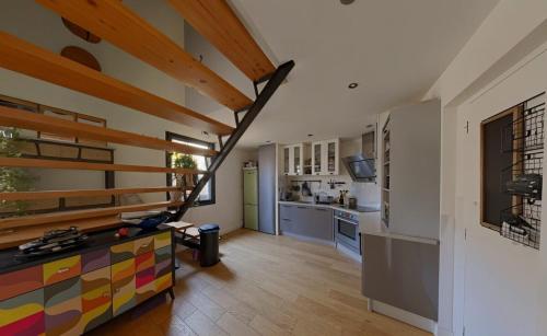 un salon avec un escalier dans une maison dans l'établissement Duplex atypique en centre-ville, à Montpellier