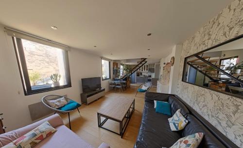 un salon avec un canapé et une télévision dans l'établissement Duplex atypique en centre-ville, à Montpellier