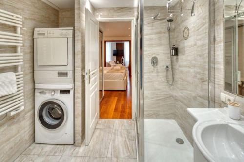 une salle de bain avec une machine à laver et un lavabo dans l'établissement Cannes 50m palais & Croisette, à Cannes
