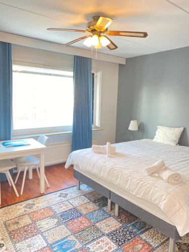 a bedroom with a bed and a table and a ceiling fan at Itäkadun Studio Apartment in Lahti