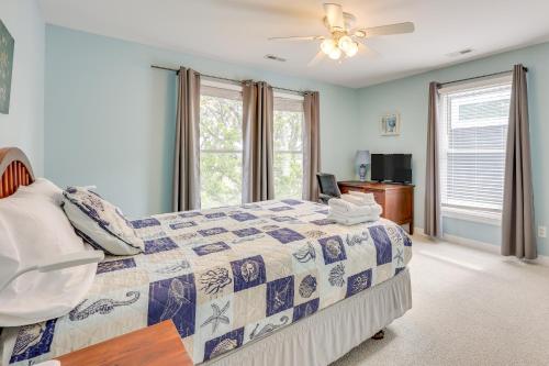 Waterfront Oak Island Home with Dock في أوك آيلاند: غرفة نوم بها سرير ومروحة سقف