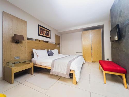 a bedroom with a large bed and a red bench at Hotel VDN by Good Rade in Dakar