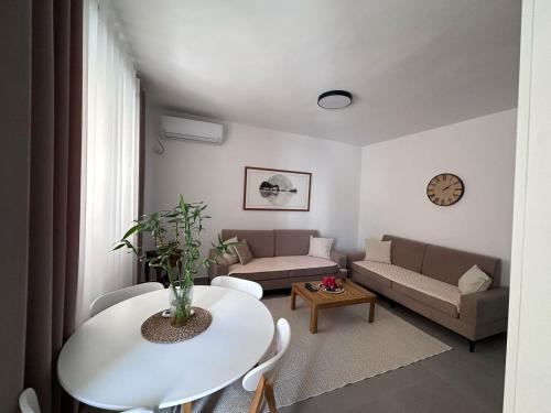 a living room with a white table and a couch at Florentina Apartments in Sarandë