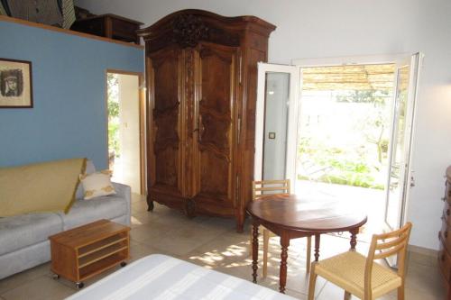 un salon avec une table et un canapé dans l'établissement Chambres d'hôtes au temps des cerises, à Pierrefeu-du-Var