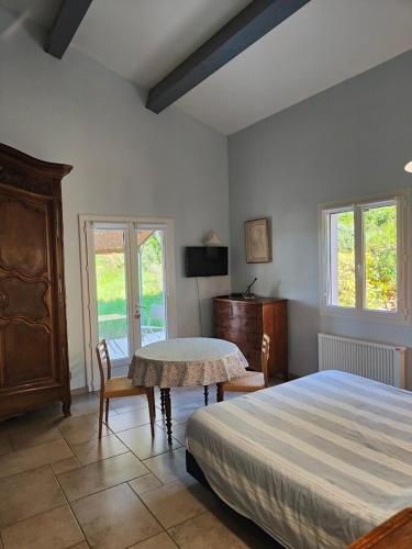 une chambre avec un lit, une table et des chaises dans l'établissement Chambres d'hôtes au temps des cerises, à Pierrefeu-du-Var