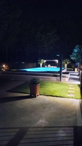 a parking lot at night with a swimming pool at RB Bed & Breakfast in Gaiba