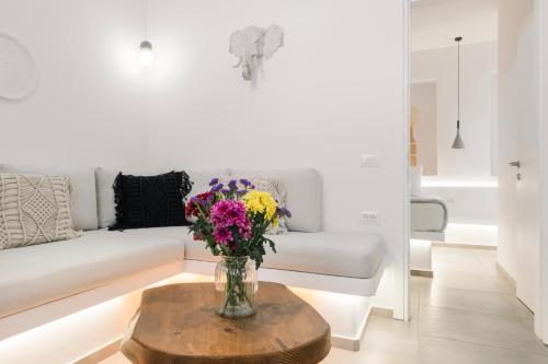 een woonkamer met een vaas met bloemen op een tafel bij August Mykonos in Mykonos-stad