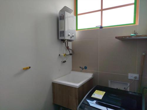 a small bathroom with a sink and a window at Relájate Cerca del Malecón con un Barril Asador para Tus Parrilladas in Guatapé