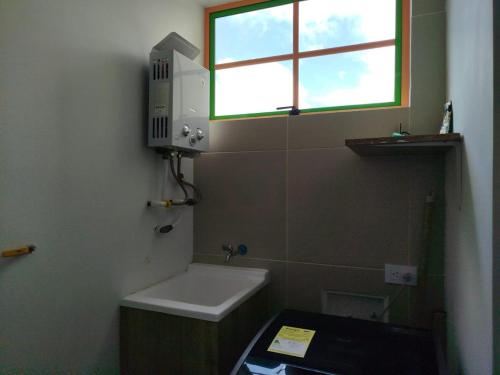 a small bathroom with a sink and a window at Relájate Cerca del Malecón con un Barril Asador para Tus Parrilladas in Guatapé