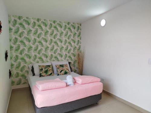 a bedroom with a pink bed and a green wall at Relájate Cerca del Malecón con un Barril Asador para Tus Parrilladas in Guatapé