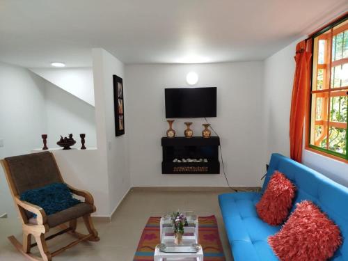 a living room with a blue couch and a tv at Relájate Cerca del Malecón con un Barril Asador para Tus Parrilladas in Guatapé