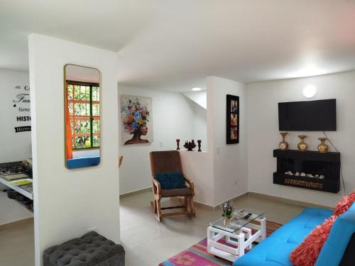 a living room with a blue couch and a tv at Relájate Cerca del Malecón con un Barril Asador para Tus Parrilladas in Guatapé