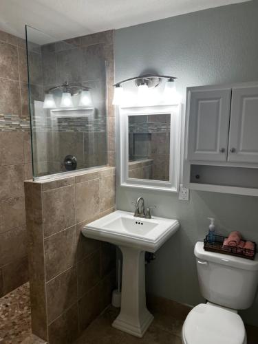 a bathroom with a sink and a toilet and a mirror at Panama City Beach, Beach Front Condo 207 in Panama City Beach