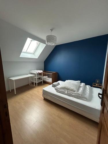 une chambre avec un mur bleu et un lit dans l'établissement Maison de ville, Gien centre, à Gien