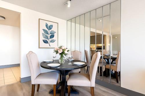 ein Esszimmer mit einem schwarzen Tisch und weißen Stühlen in der Unterkunft XL Center 1-BR Condo DWNTN Hartford Easy Parking in Hartford