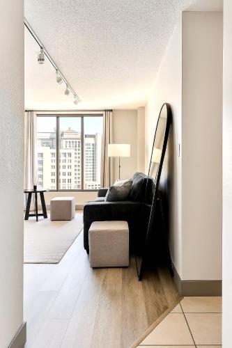 ein Wohnzimmer mit Couch und großem Fenster in der Unterkunft XL Center 1-BR Condo DWNTN Hartford Easy Parking in Hartford