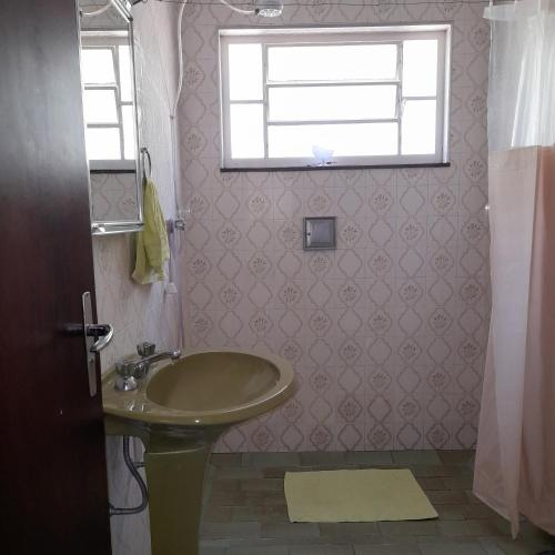 a bathroom with a sink and a window at Hostel Junqueira in Tatuí