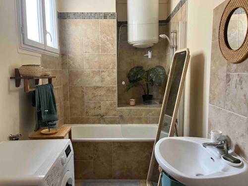 une salle de bain avec un lavabo et une baignoire dans l'établissement Charmant 2 pièces dans le quartier chic du Parc des Princes, à Boulogne-Billancourt