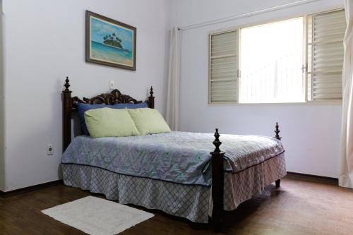 a bedroom with a bed and a window at Hostel Junqueira in Tatuí