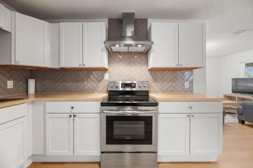 a kitchen with white cabinets and a stove at Spacious McKinney Bungalow - 4 Bedrooms in McKinney