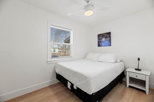 a white bedroom with a bed and a window at Spacious McKinney Bungalow - 4 Bedrooms in McKinney